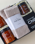 Bath salts, coconut milk bath, 2 pairs of cozy socks, massage candle and card game for couples in a black gift box.